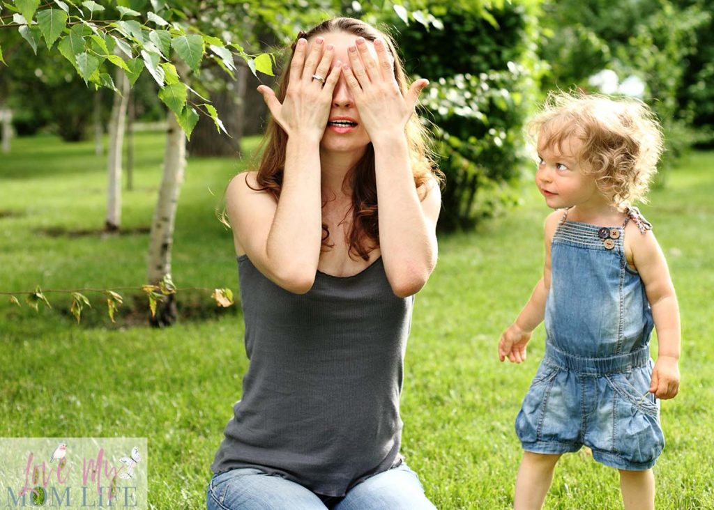 mom and toddler playing hide and seek game outside